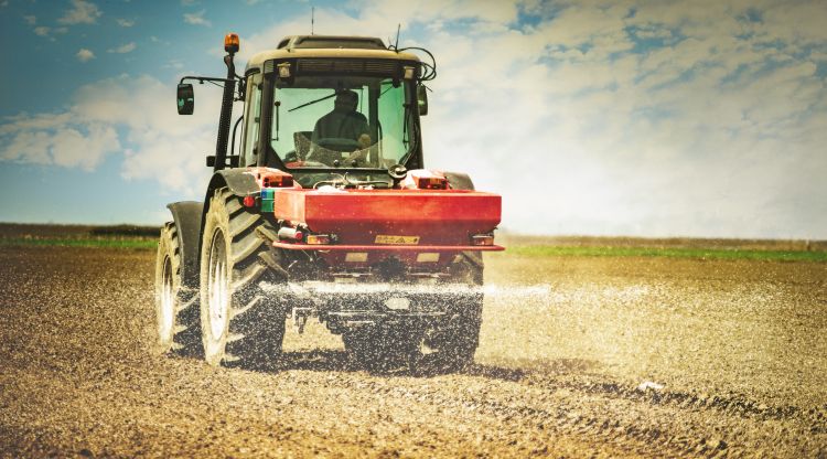 Traktor műtrágyát szór a táblán